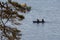 lake and the boat in which two people sit