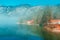 Lake Bohinj landscape in winter morning, fog rising over clean glacial water in slovenian national park Triglav