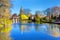 Lake in Bruges, Belgium, church and medieval houses reflection in water