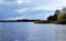 Lake, cloudy sky and trees on the shore