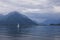 Lake Comersee with mountains and sailing boat, dramatic clouds, Italy