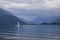 Lake Comersee with mountains and sailing boat, dramatic clouds, Italy