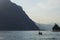 Lake Como in the Italian city of Lecco surrounded by mountains. A sailing yacht. Evening sunshine.