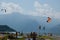 Lake Como, Italy - July 21, 2019: People resting on beach near lake. Windsurfers and kitesurfers preparing equipment for surfing.