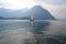 Lake Como at Lecco with sailboat moving away from the city.