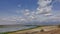 A lake in the dry African savanna. There is green vegetation on the banks.