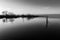 Lake at dusk with perfect reflections, wooden poles in the fore