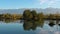 Lake at the edge of the mountains with forest reflected in the clear water. Idyllic autumn landscape. The forest and the sky in th