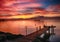 lake on fire with roman boat. Yellow, orange, red and pink plume with blue sky.