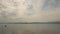 Lake with Floating People on the Background of Mountains in Cloudy Weather. Ripples on the Water Surface in the Pond