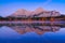 Lake and forest in a mountain valley at dawn. Reflections on the surface of the lake. Mountain landscape at dawn.