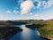 Lake in a green field under blue cloudy sky in Quebec, Canada