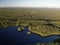 Lake in green summer forest with cloudy sky. Aerial view Russian Karelia. Sunset