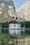 Lake Koenigssee with st Bartholomew`s church surrounded by mountains in Germany.