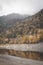 Lake Kruth-Wildestein in Vosges with low waterlevel and autumnal trees on mountains. dark moody skies