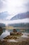 Lake Laghi di Fusine on foggy morning with mountain Mangart