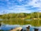 Lake landscape. Bright colors. Wooden pier on the lake, household items for outdoor recreation.