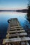 Lake landscape with small old wooden pier photographed on long exposure