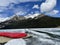 Lake Louise in Banff National Park in late May where it is partially frozen showing the red canoes