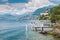 Lake Lugano. View of Campione d`Italia, famous for its casino visible on the right, with a tourist boat arriving