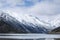 Lake with majestic mountains reflected in the still water of the shoreline