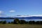 Lake Manapouri - bush , meadow , coastline, mountains, clouds, blue sky
