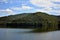 Lake mirroring rocky mountains with forest fir trees on summer season