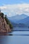 Lake mirroring rocky mountains with forest fir trees on summer season