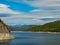 Lake mirroring rocky mountains with forest fir trees on summer season