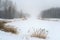 Lake in misty haze of winter blizzard