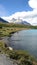 lake mountains peak snow clouds blue sky river edge water