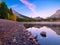 Lake and mountains in a valley at dawn. Reflections on the surface of the lake.