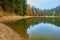 Lake in mystery fog with autumn forest. Ghostly mountain lake