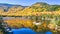 Lake in New Hampshire reflecting colorful peak fall mountains and lone rocky island with pine tree