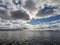 Lake Onega under huge Cumulus clouds developing in the blue sky