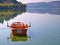 Lake Orestiada, Kastoria, Greece,  boat and reflection on calm water. Trees and mountains mirroring on water surface