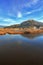 Lake overgrown with reeds mountains in background