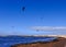 Lake with people parachuting over it in the bright skyline