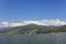 Lake Phewa on the background of a green mountain valley and the snowy top of Mount Annapurna under a blue sky, view from the water