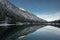 Lake plansee at winter sunrise with mirroring alpine mountain