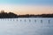 a lake with poles in it and birds flying by on them