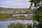 Lake with reeds and willows on the shore near the forest during spring months