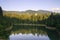 Lake reflection of a forest at sunset