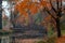 Lake reflections of fall foliage and ancient bridge