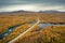 Lake, river, road and mountains with yellow trees in autumn along the scenic Wilderness Road in Lapland in Sweden from above