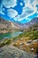 Lake in rocky mountains with lichen rock in foreground