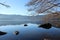 .Lake Sanabria, Zamora, a sunny winter day. the lake is calm, there are rocks and trees