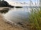 A lake with sand and grass surrounding it