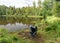 Lake shore and fisherman`s chair, calm lake water surface, tree reflections, cloudy day, fishing concept