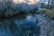 Lake shoreline with rocks, bushes and morning light